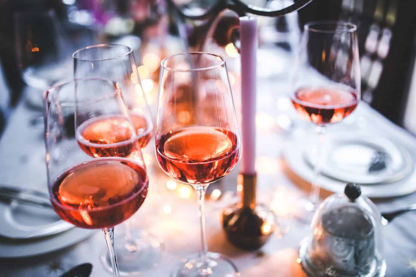 Four glasses of rosé wine on table.